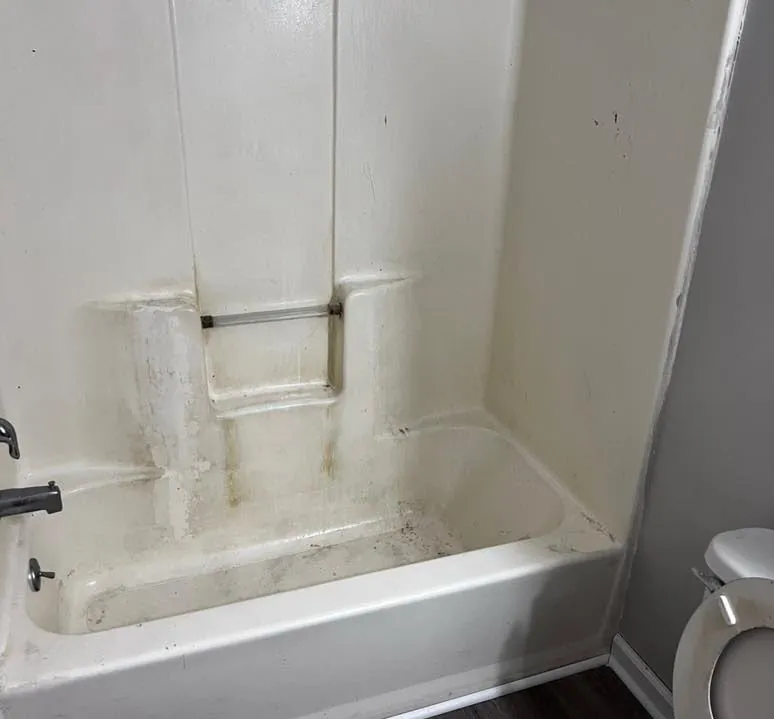 Stained fiberglass tub and shower surround before deep cleaning