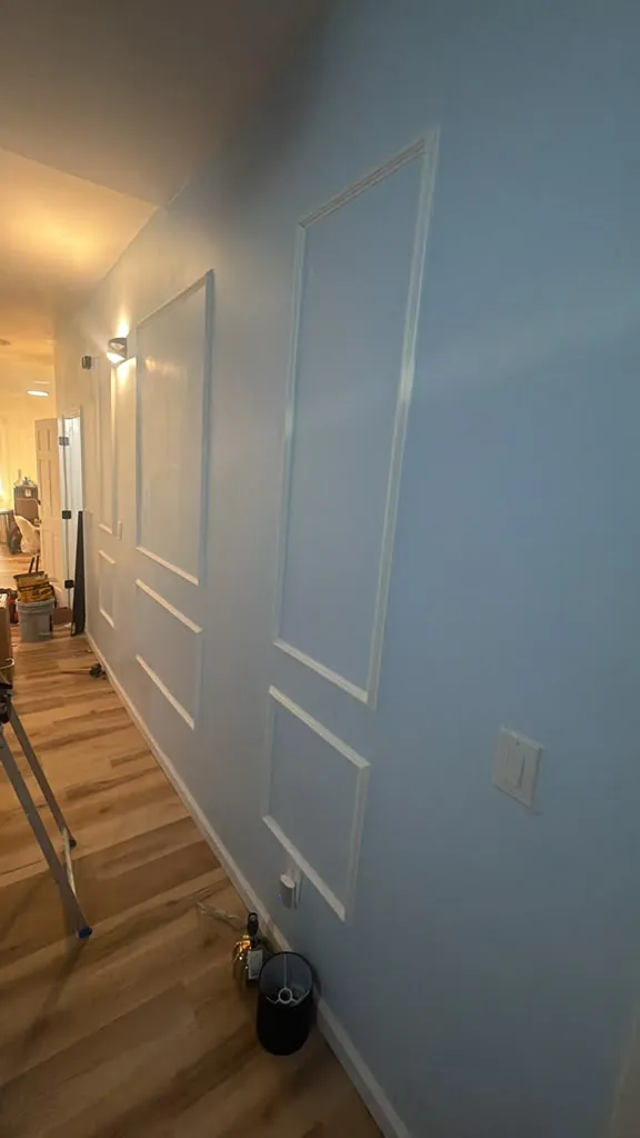 Hallway wall with freshly painted picture-frame trim molding, dust-free after cleaning